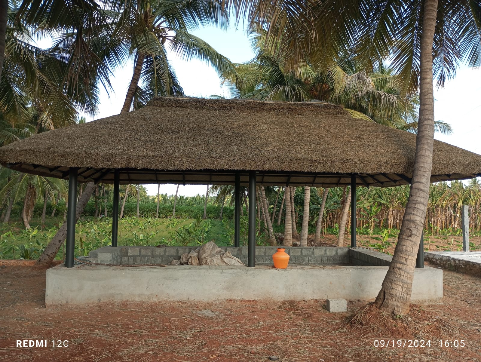 Craftsman weaving coconut palm leaves for a thatched roof